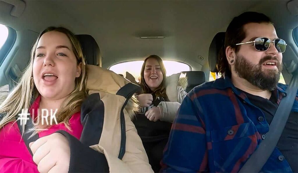 Tweeling Gerda en Mathilde zitten met Klaas in de auto tijdens de opnames van de serie Urk.