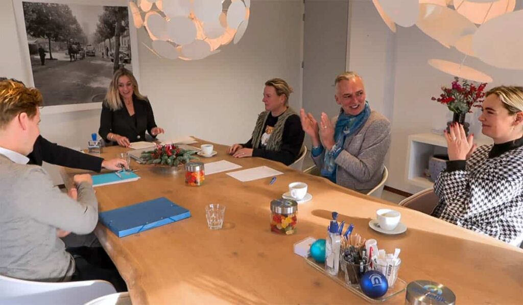 Martien, Erica en Maxime zitten bij de notaris om te tekenen voor de aankoop van pension Code Rosé tijdens de aflevering van Chateau Meiland.