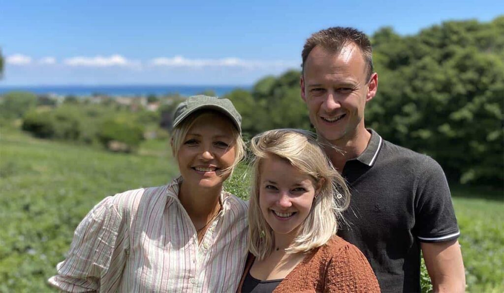 Onze Boerderij in Europa presentatrice Yvon Jaspers staat met Boer Zoekt Vrouw koppel Jouke en Karlijn in een veld in Frankrijk.