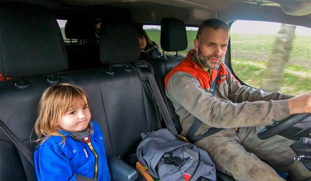 Johan Doff rijdt auto met de kinderen van de familie tijdens het programma Bij ons op de Boerderij.