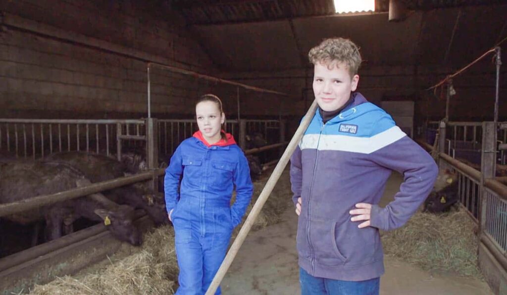 Kinderen van de familie Van den Hurk aan het werk in de stal in het RTL5 programma Bij ons op de Boerderij