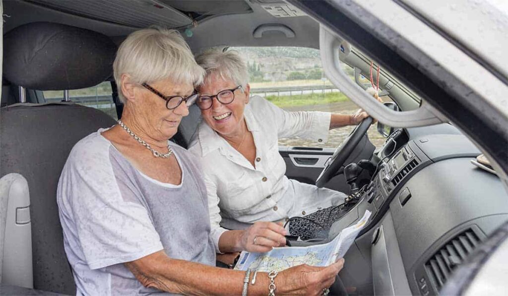 We zijn er Bijna 2023 deelnemers Brenda en Renée zitten lachend in de camper onderweg in Italië. Beeld bron: Brenda en Renée | © Ruud Taal/MAX