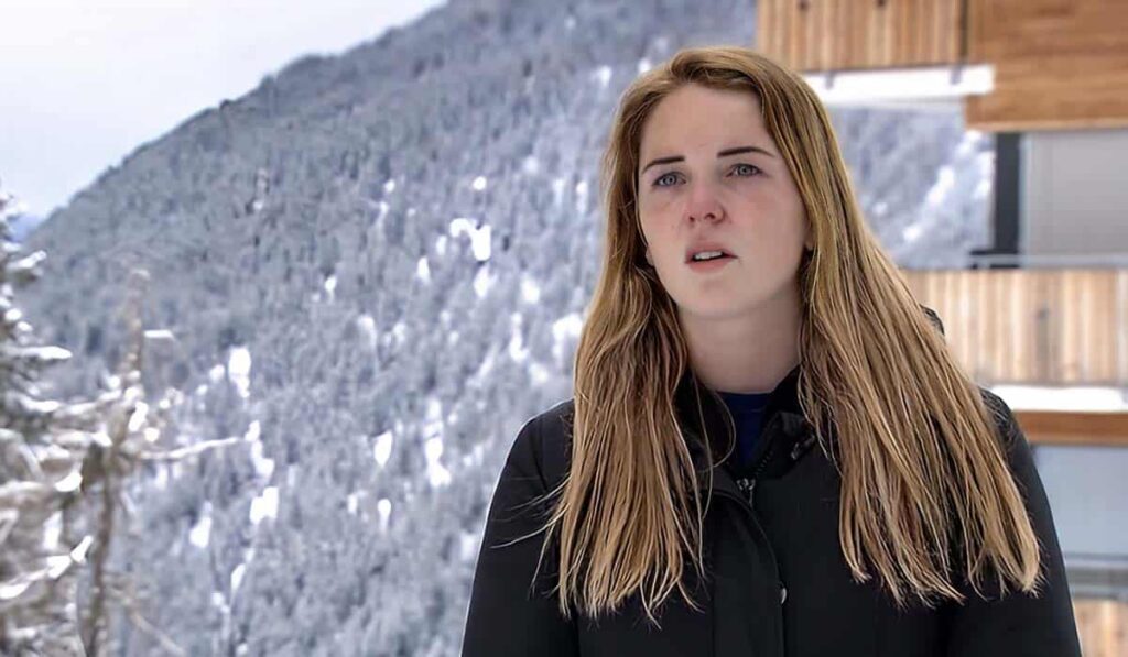 Winter Vol Liefde deelneemster Kelsey staat voor een besneeuwde berg in Riederalp Zwitserland