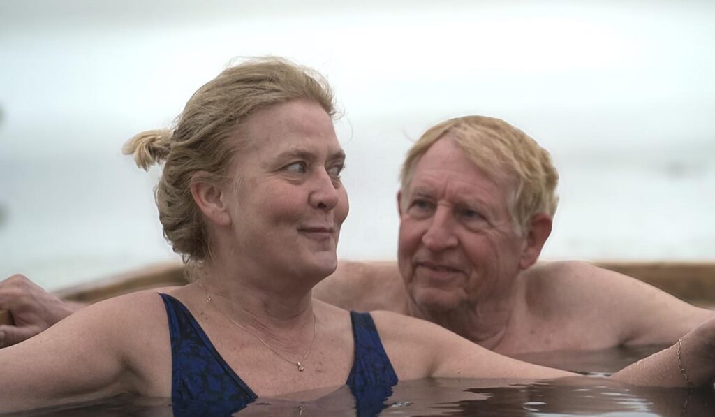 Man en vrouw zitten in ijswater in een sneeuwlandschap (Annette en Maarten uit Winter Vol Liefde)