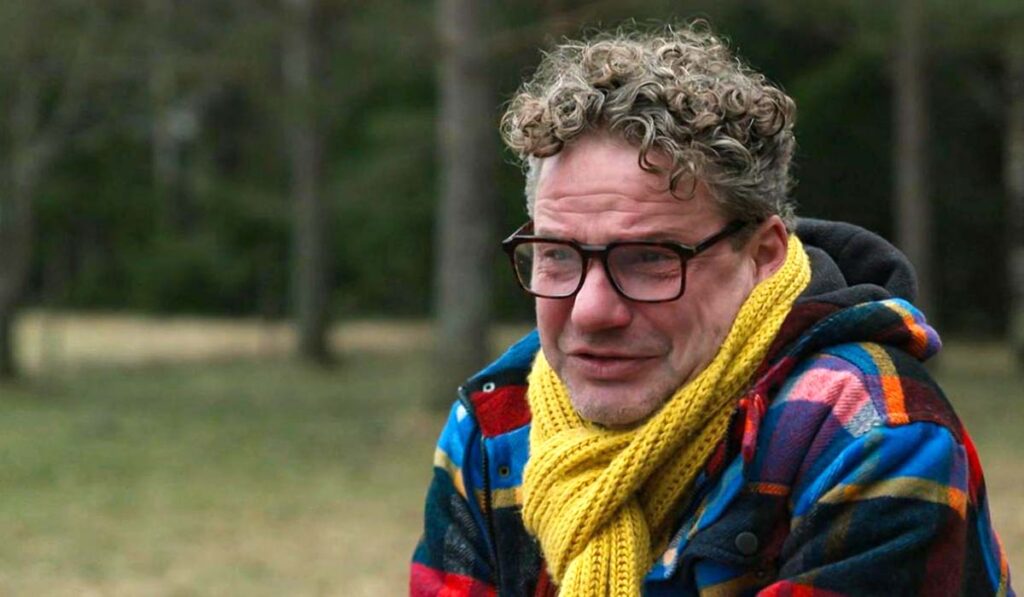 Man met bril en gele sjaal (Michiel uit Winter Vol Liefde) huilt